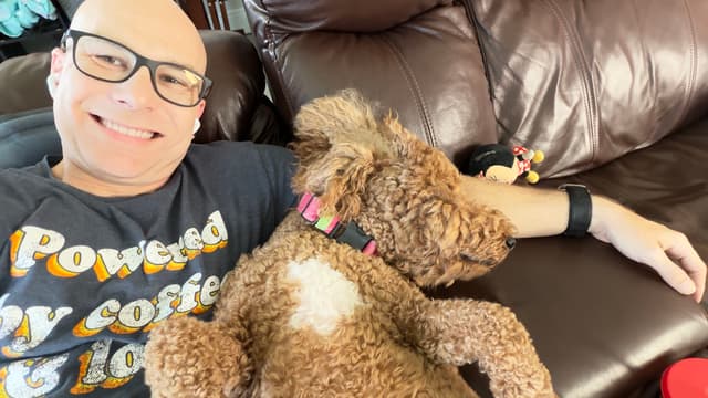 Leia resting against her smiling handler on a sofa